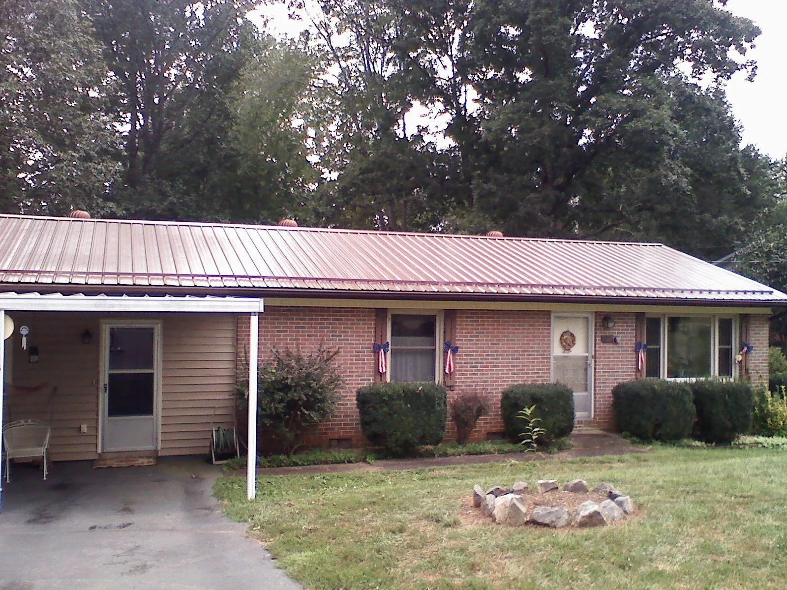 Bronze metal roof and carport on a brick ranch home — Roof Repair work by our crew in Plush